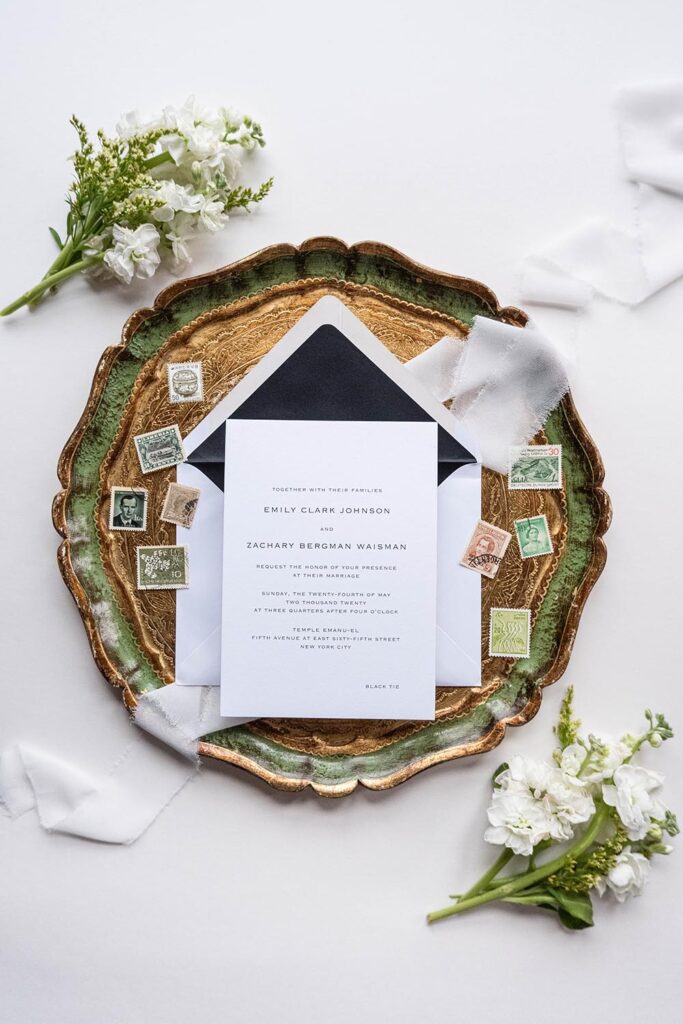 white wedding invitations on green and brown clay plate