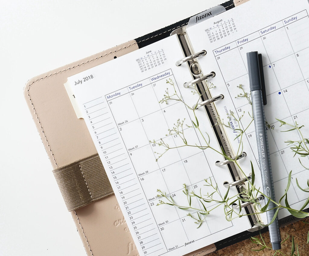 calendar notebook under green stems
