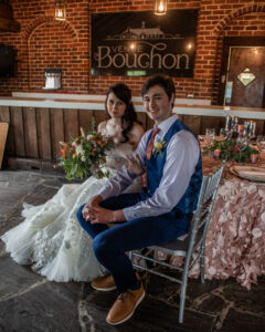 newly wed couple sitting at reception table and smiling
