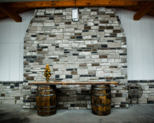 rustic barrel table in front of stone accent wall